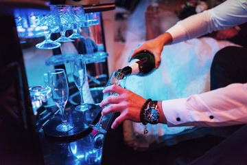 waiter pours champagne into glass