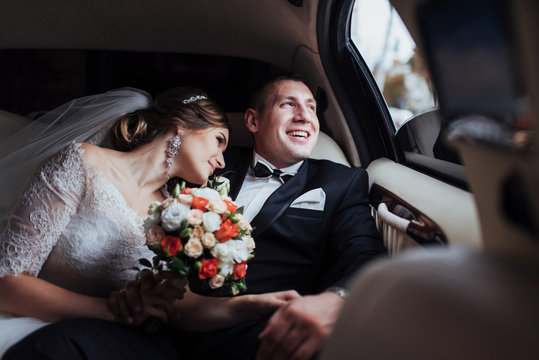 young couple in a car in wedding day.