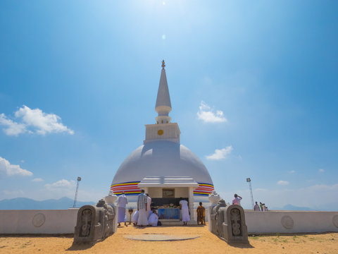 Pilgrims in white dress worshiping White Stupa Dagoba Dagabo at Nelligala International Buddhist Center, Kandy, Sri Lanka