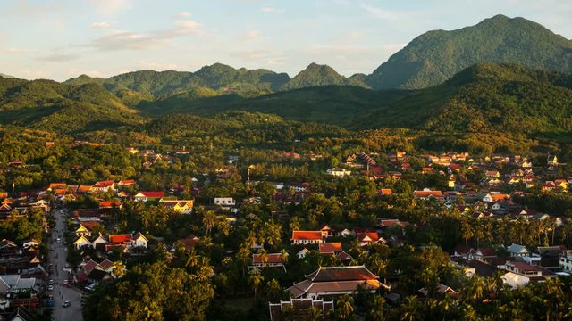 Luang Prabang, Laos. Aerial view of Luang Prabang town in Laos. Small touristic city surrounded by mountains. Colorful sky. Day to night time-lapse