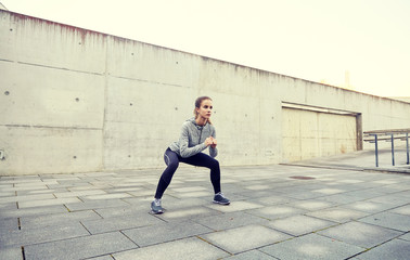 Fototapeta na wymiar happy woman doing squats and exercising outdoors
