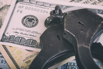 Dollars and handcuffs. Financial crime, illegal activity