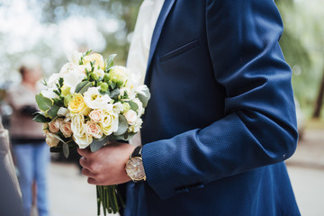 wedding bouquet in hands of the groom