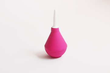 Pink enema on a white background isolated closeup