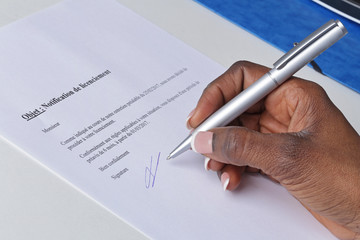 main femme noire signant une lettre de licenciement