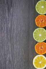 Fototapeta na wymiar Lemons, tangerines and limes on grey wooden table.