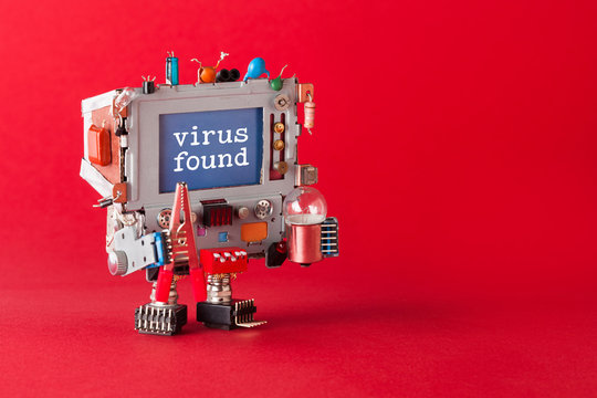 Virus found and cyber safety concept. Tv robot handyman with pliers and light bulb in hands. Warning message spyware detected on blue screen monitor. macro view, red background copy space.