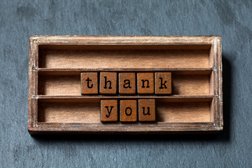 Thank you concept. Vintage box, wooden cubes phrase with old style letters. Gray stone textured...