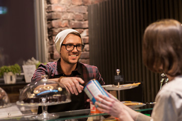 man or barman serving customer at vegan cafe