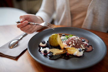 woman eating ice cream dessert at restaurant