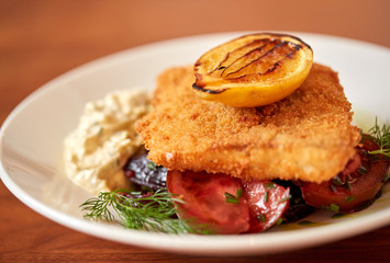 close up of fish salad with roasted lemon on plate
