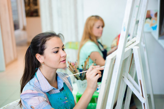 beautiful young girls draws a picture paints on art lesson