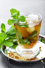 Mint Julep cocktail with bourbon, ice and mint in glass on black background
