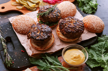 Ingredients for a tasty and juicy burger home in a rustic style with a big chop of beef