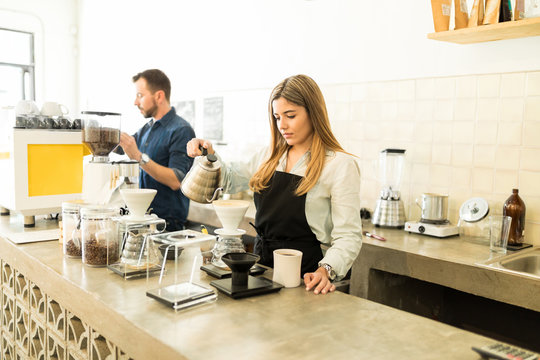 Busy Baristas Working In A Coffee Shop