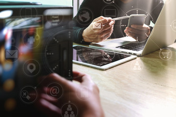 Designer Businessman hand using smart phone,mobile payments online shopping,omni channel,digital tablet docking keyboard computer in modern office on wooden desk,virtual interface icons screen