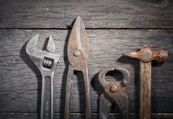 Old locksmith tools on a gray and cracked wooden background. Space for text. View from above.