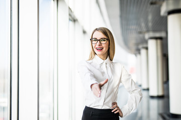 Business woman give an handshake on camera.