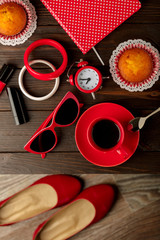 Cup of coffee with cupcakes, notepad, accessory, shoes and sunglasses.