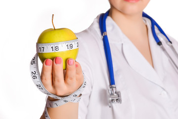 Apple with measuring tape that holds the nurse or doctor nutritionist in a white coat and a...