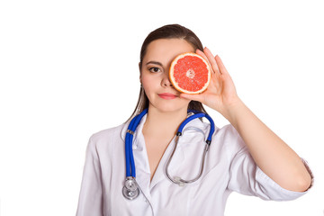 A young and handsome doctor nutritionist with grapefruit in a hand near the face on a white...