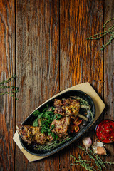 Spicy steak of the lamb chop iron pan. Food on dark wood background.