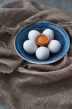 fresh eggs collected in the plate for cooking on the fabric.