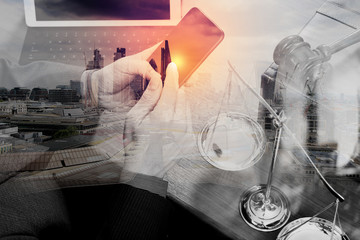 double exposure of justice and law concept.Male lawyer in office with the gavel,working with smart...