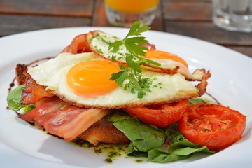 Fototapeta na wymiar Breakfast with fried eggs, bacon and tomatoes.