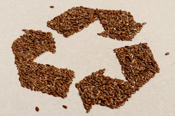 Recycling Symbol Made of Flax Seeds on Recycled Paper Background