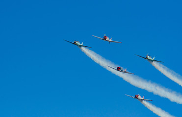 Vintage planes in formation with smoke trails