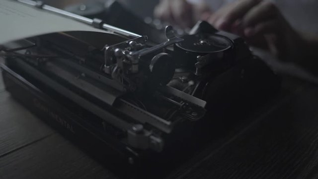 Man typing text on retro typewriter.