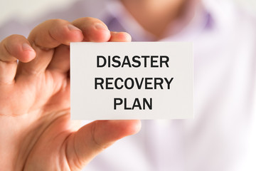 Businessman holding DISASTER RECOVERY PLAN card