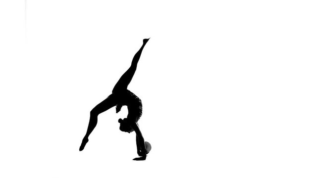 Gymnast with the ball in his hands flips forward. White background. Silhouette. Slow motion