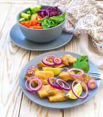 Crispy fried fish tilapia and green vegetable salad
