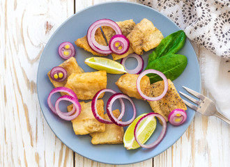 Crispy fried fish tilapia with lime and pickled onion