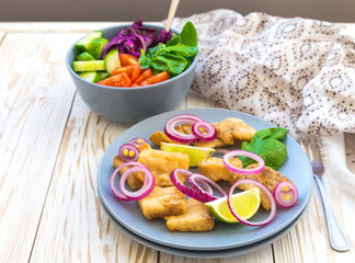 Crispy fried fish tilapia and green vegetable salad