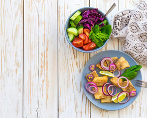Crispy fried fish tilapia and green vegetable salad