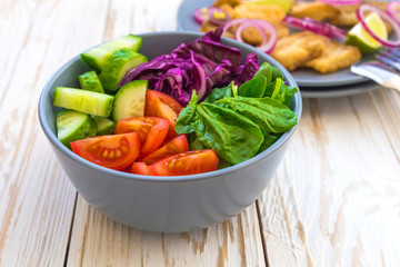 Crispy fried fish tilapia and green vegetable salad
