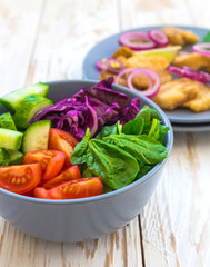 Crispy fried fish tilapia and green vegetable salad