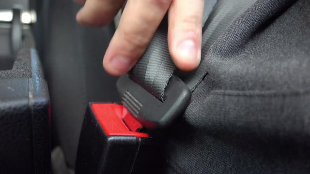 Driver fastening/unfastening car seat belt