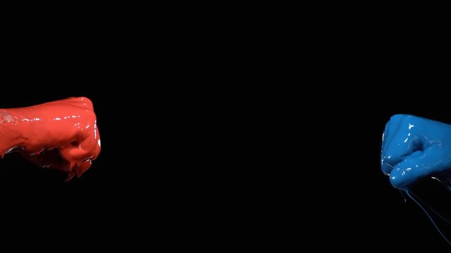 Two fists painted blue and red punching each other. Shot with high speed camera, phantom flex 4K. Slow Motion.