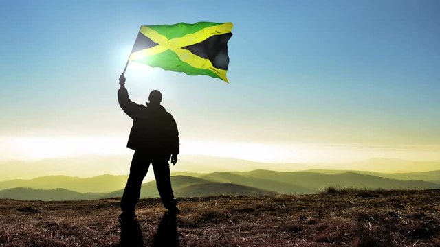 silhouette man waving Jamaica flag 