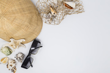 Fototapeta premium holiday setting with hat, sunglasses and seashells on white background