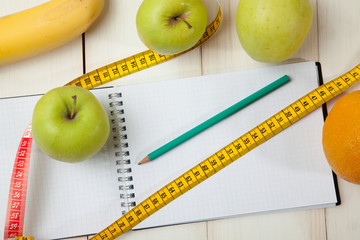 Fruits and diet plan on a white wooden table