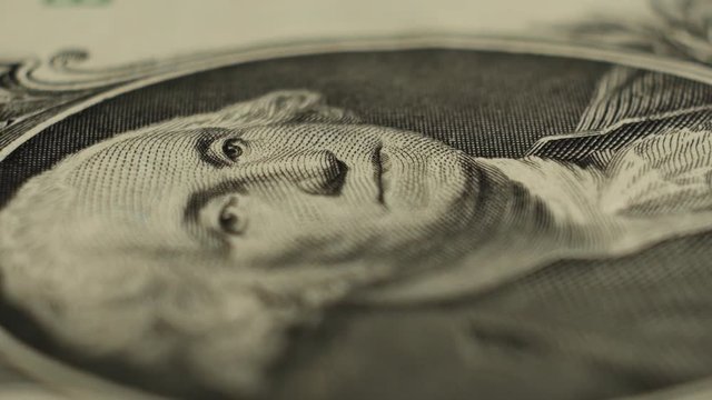 One dollar banknote with a rotating President George Washington's image, macro shot.