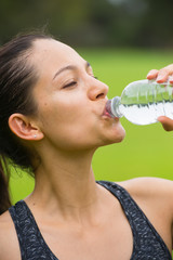 Young exercising woman drinking water