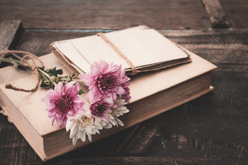 Vintage novel books with bouquet of flowers on old wood background - concept of nostalgic and...