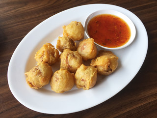 Shrimp fired balls with spicy sauce on wooden table background