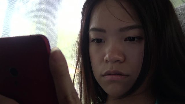 Closeup Asian Woman Used Touchscreen Tablet Smartphone Device, Young Woman Watching Video On Touchpad, Then Choosing Another One During Day Ride In The Bus, 4K -Dan